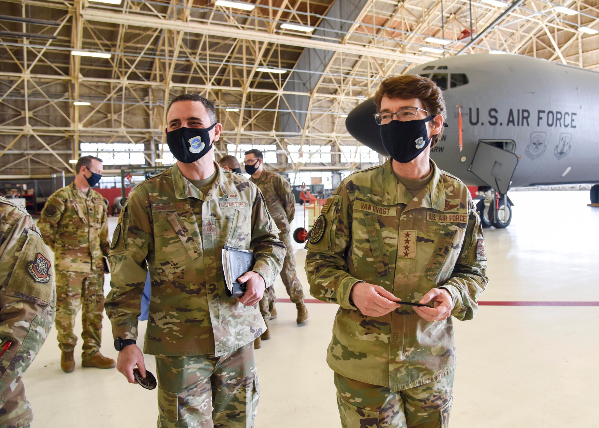 U.S. Air Force Gen. Jaqueline Van Ovost, Air Mobility Command commander and Chief Master Sgt. Brian Kruzelnick, AMC command chief, receive honorary 92nd Maintenance Squadron patches after participating in a Multi-Point Refueling System demonstration at Fairchild Air Force Base, Washington March 4, 2021. 92nd MXS Airmen discussed the mechanics of the MPRS program and its impact on the mission. (U.S. Air Force photo by Airman 1st Class Anneliese Kaiser)