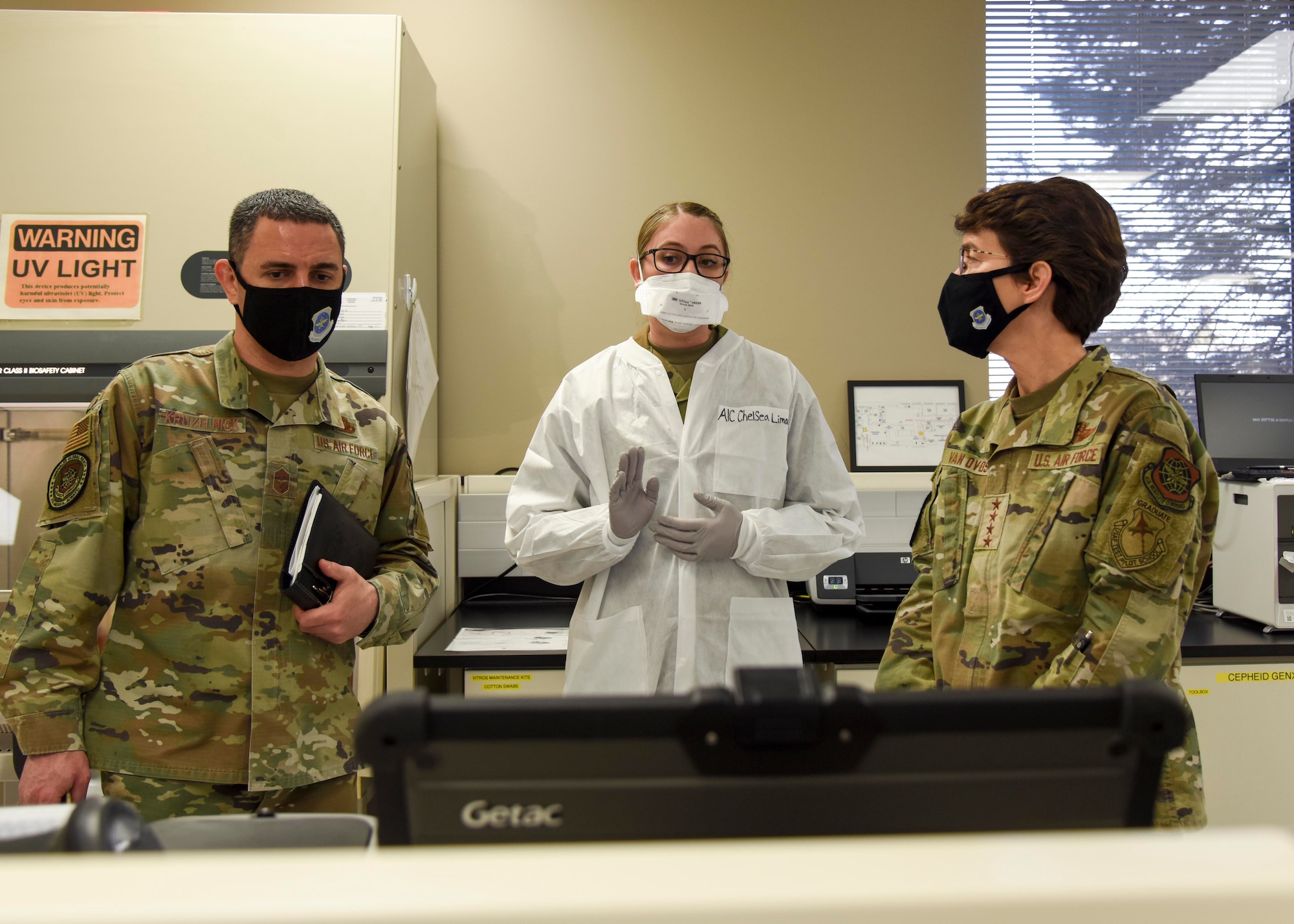 U.S. Air Force Airman 1st Class Chelsea Limacher, 92nd Medical Group laboratory technician, shows Gen. Jacqueline Van Ovost, Air Mobility Command commander and Chief Master Sgt. Brian Kruzelnick, AMC command chief, the Coronavirus-19 processing lab at Fairchild Air Force Base, Washington, March 4, 2021. The AMC command team learned how to perform a COVID-19 swab, run the test and interpret and communicate the results.  (U.S. Air Force photo by Airman 1st Class Anneliese Kaiser)