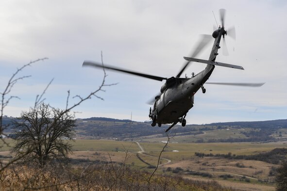 Two pararescuemen escort a downed pilot to a U.S. Air Force HH-60G Pave Hawk helicopter during Operation Porcupine in Romania, March 4, 2021.