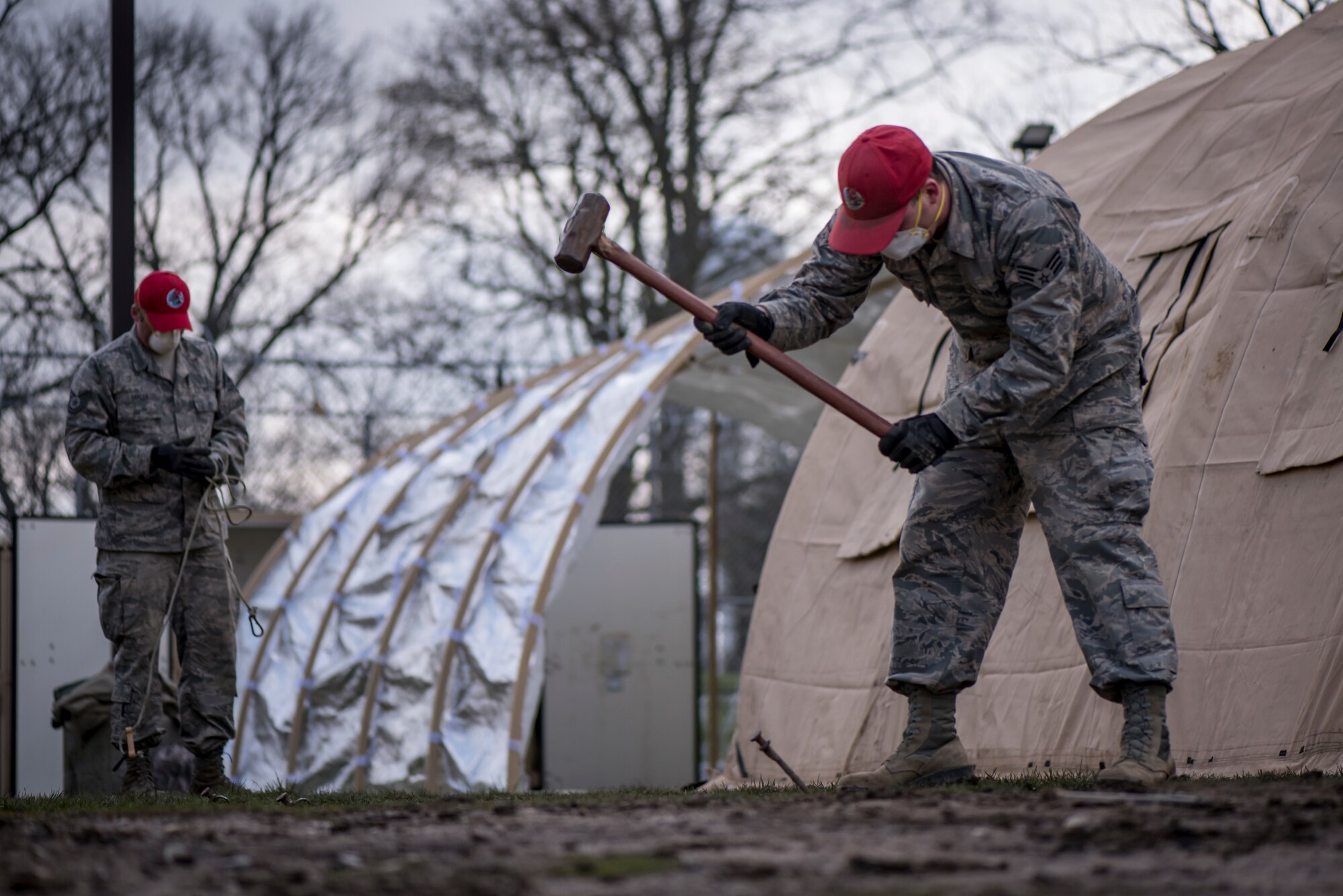Senior Airman Michael Hyer stakes a tent down while working with Ohio National Guard members supporting the Ohio Department of Rehabilitation and Correction in response to confirmed COVID-19 cases at the Pickaway Correctional Institution, Orient, Ohio.