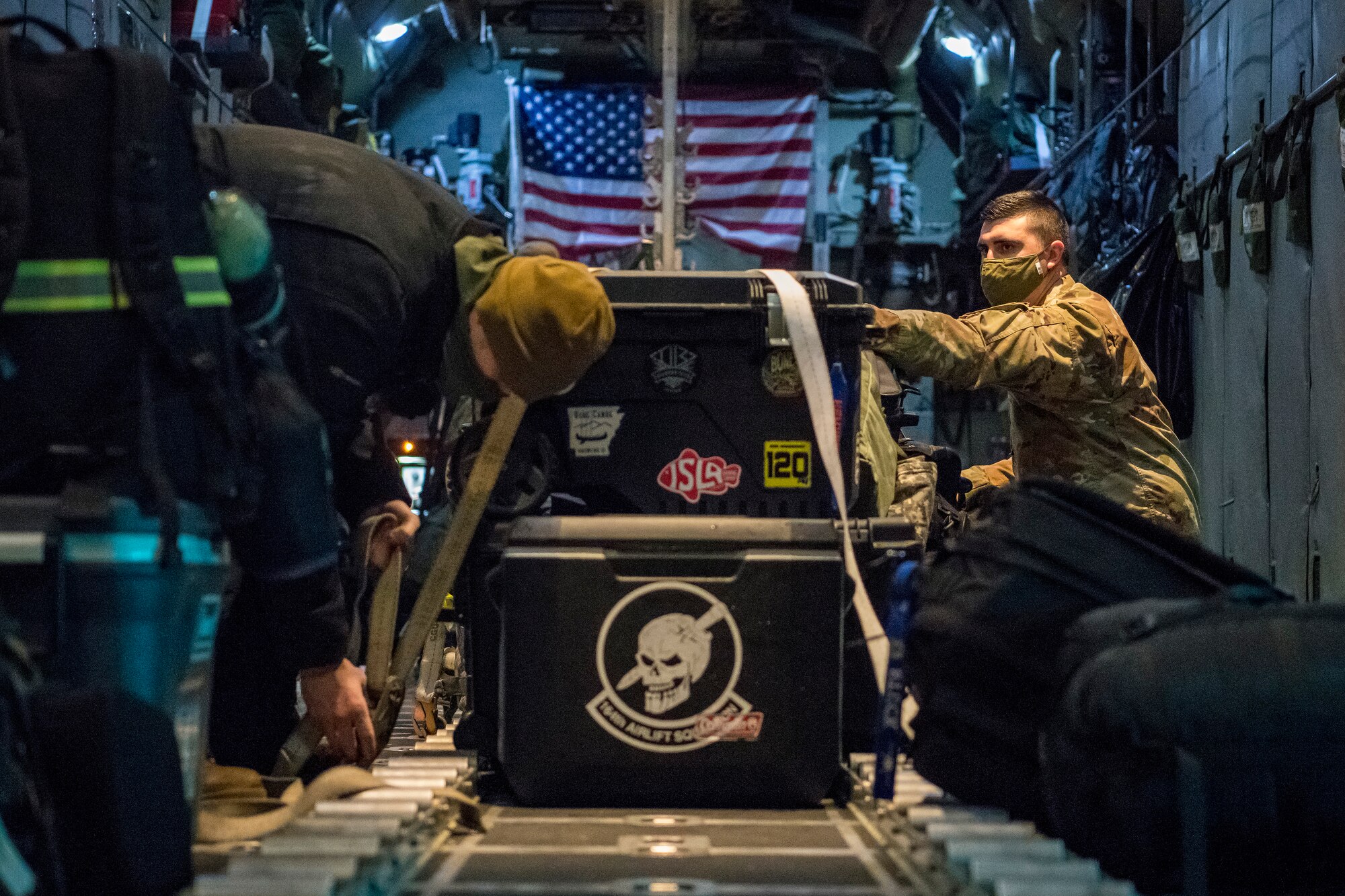 Airmen load a C-130 and strap cargo down