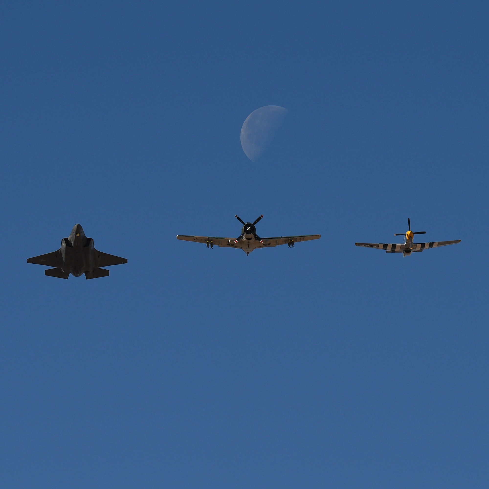 An F-35A Lightning II, an A-1 Skyraider and a P-52 Mustang in flight