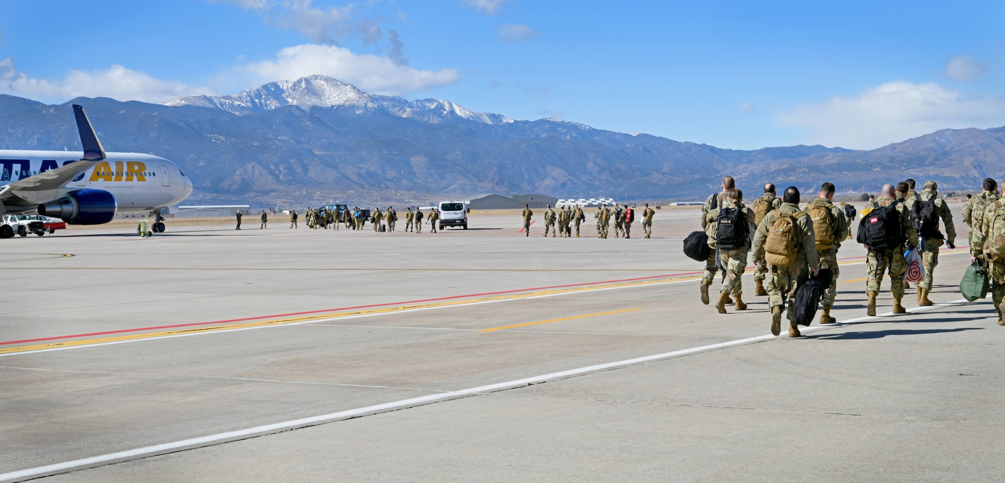 Members from the 302nd Airlift Wing prepare to board a commercial airliner after saying good-bye to coworkers, family and friends before departing to an undisclosured location Feb. 5, 2021, Peterson Air Force Base, Colorado.