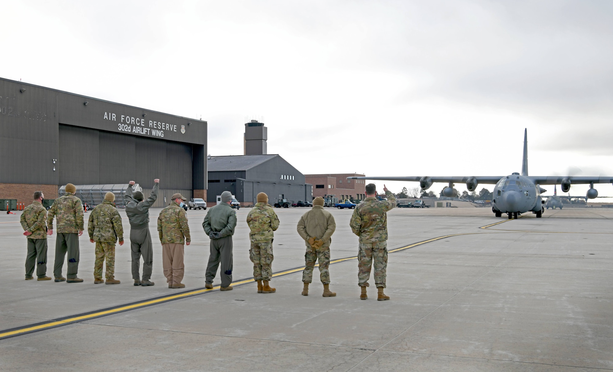 Leadership from the 302nd Airlift Wing bid an enthusiastic farewell to members aboard a C-130 aircraft before they depart to an undisclosured location Feb. 5, 2021, Peterson Air Force Base, Colorado.