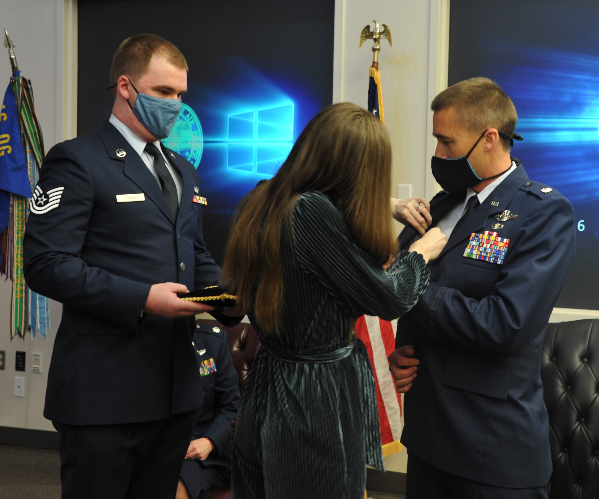 Lt. Col Daniel Arneson receives commander's pin from his wife, Heather, after becoming the new commander of the 728th Airlift Squadron during a change of command ceremony at Joint Base Lewis-McChord, Washington, March 6, 2021.