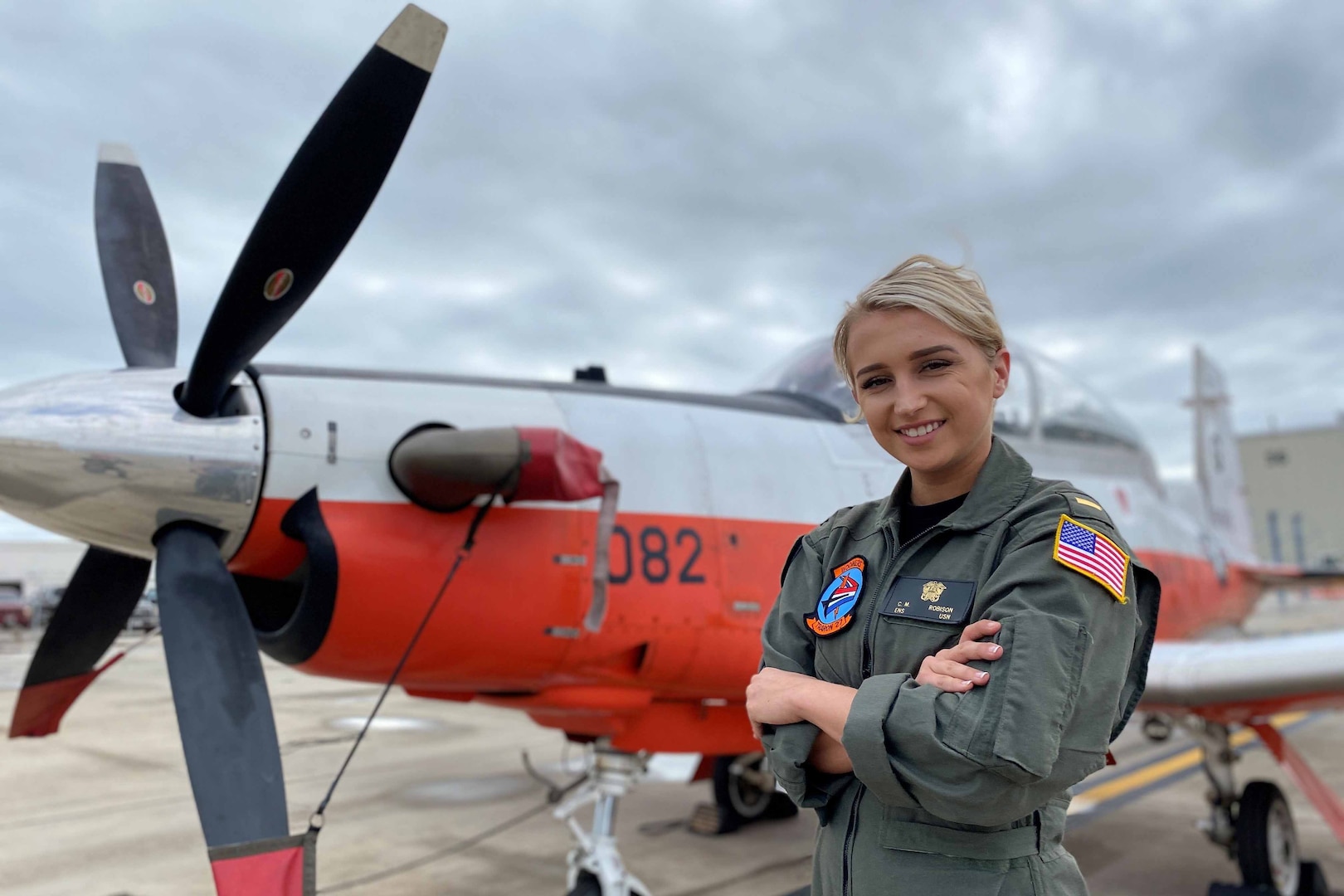 Aviator stands in front of an aircraft.