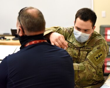 A Soldier with the Michigan Amy National Guard serving with Michigan National Guard’s COVID-19 Vaccination Testing Team administers a COVID-19 vaccination in Augusta, Michigan, March 3, 2021. The Michigan Army and Air National Guard hosted a vaccination clinic for service members and Department of Defense personnel at Fort Custer Training Center.