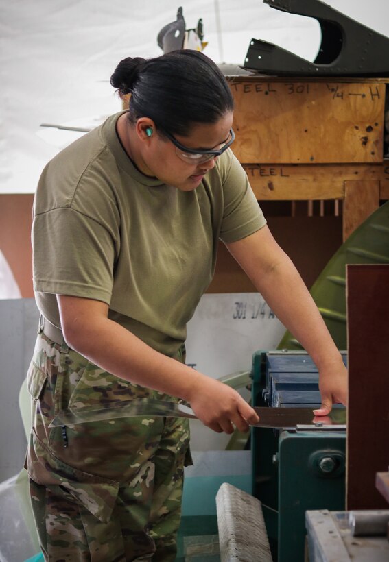 Pfc. Genevieve Godgow, an aircraft structural repairer attached to 3rd Battalion, 238th General Support Aviation Battalion, Delaware Army National Guard, smiles for a picture in front of a UH-60 Blackhawk at Camp Bondsteel, Kosovo, on March 3, 2021.