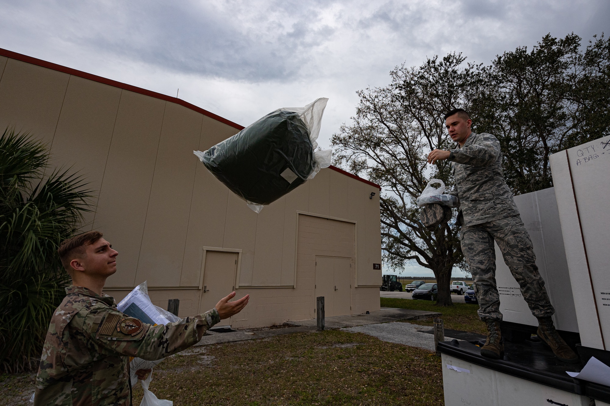 A photo of Airmen taking sleeping bags from a box