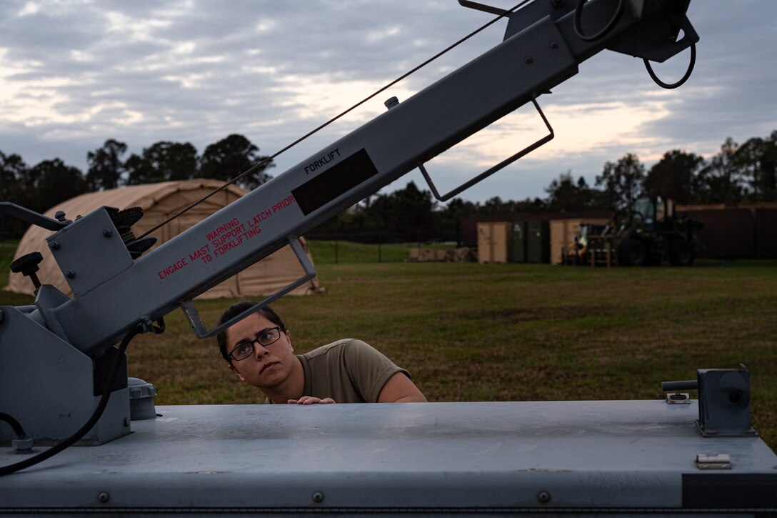 A photo of an Airman breaking down a light tower