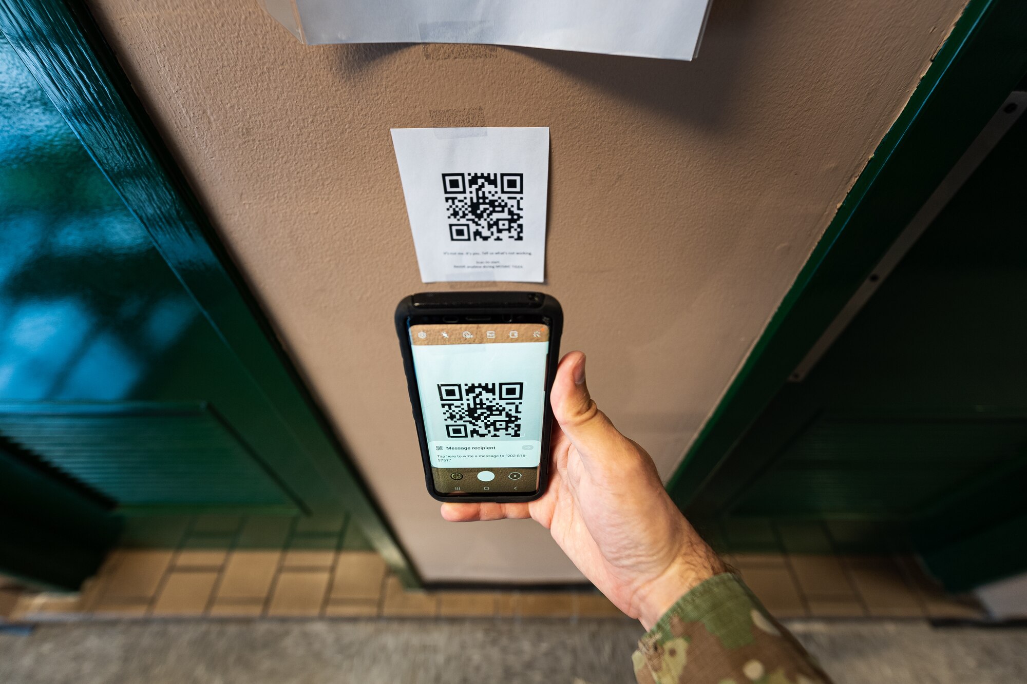 A photo of an Airman scanning a QR code