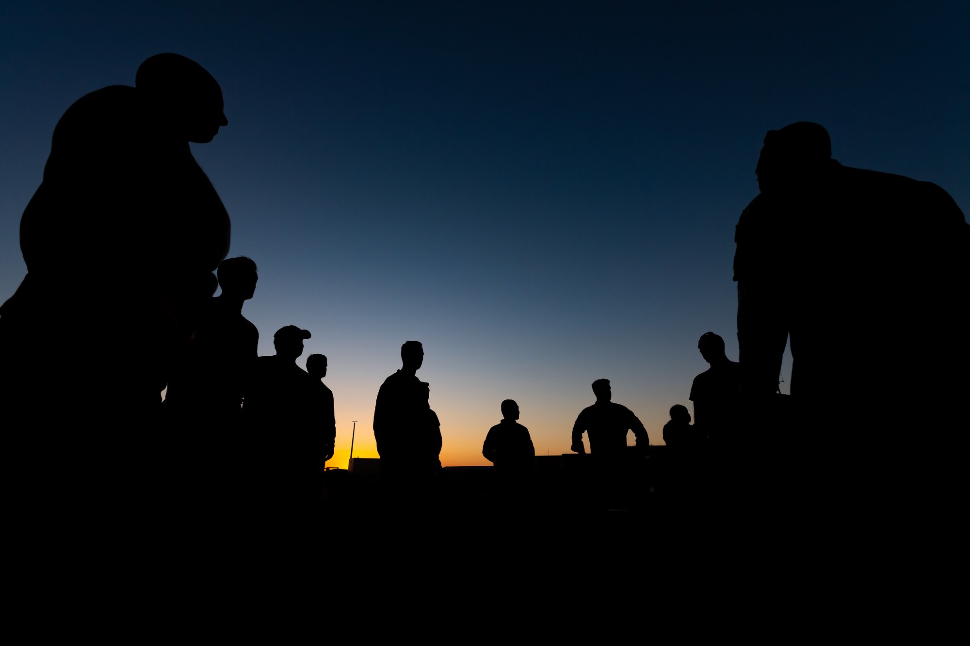 A photo of Airmen meeting during sunset