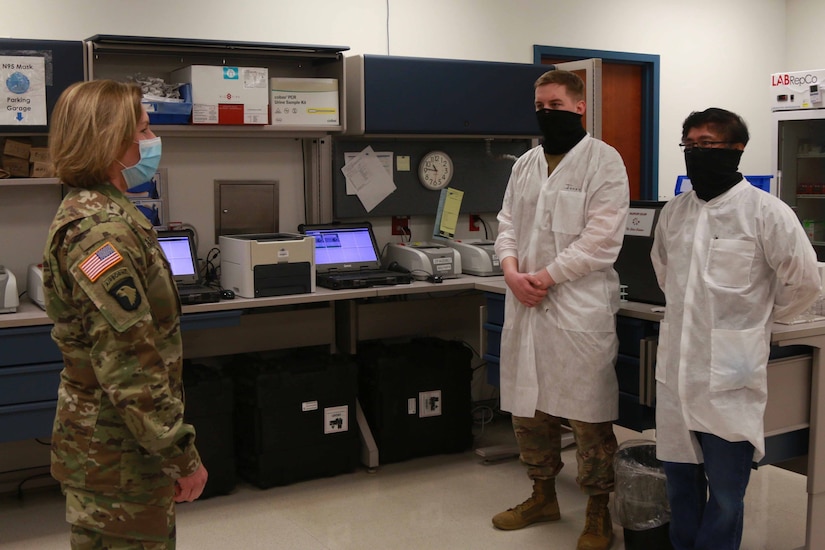 A general speaks with medical personnel in white coats.