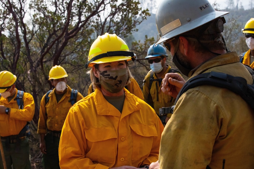 A general speaks with a firefighter.