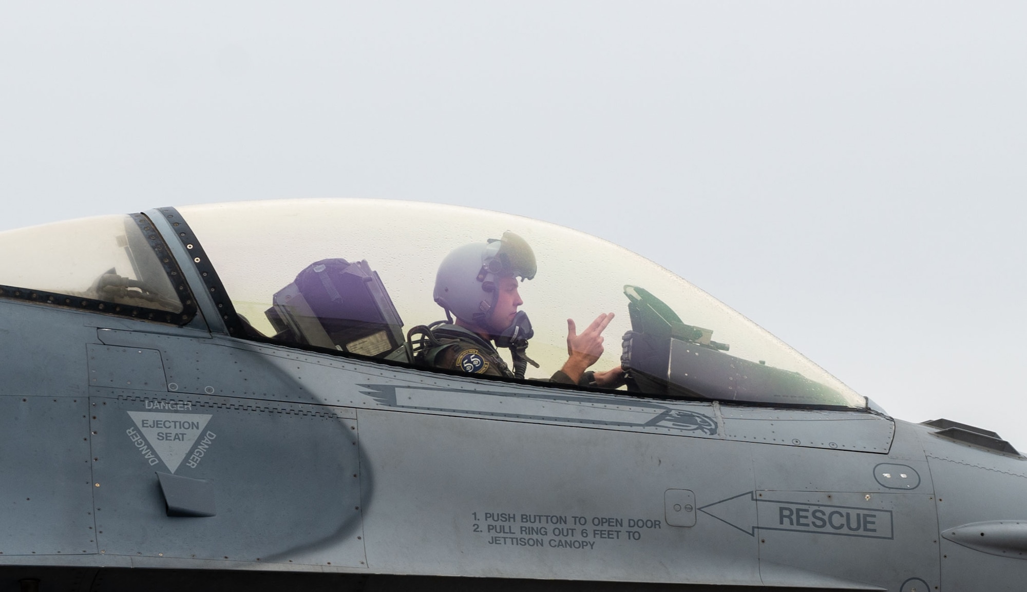 Image of a pilot giving the 55th Fighter Squadron, Shooters, hand signal while taxiing.