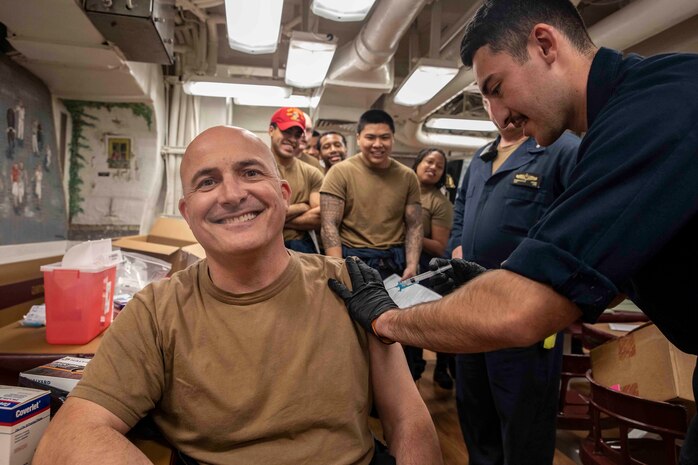 210220-N-BM428-0070 SOUDA BAY, Greece (Feb. 20, 2021) Cmdr. Thomas Ralston, commanding officer of the Arleigh Burke-class guided-missile destroyer USS Porter (DDG 78), receives the COVID-19 vaccine from Hospital Corpsman Kevin Gonzalez in Souda Bay, Greece, Feb, 20, 2021. Porter, forward deployed to Rota, Spain, is on its ninth patrol in the U.S. Sixth Fleet area of operations in support of U.S. national interests and security in Europe and Africa. (U.S. Navy photo by Mass Communication Specialist 2nd Class Damon Grosvenor)