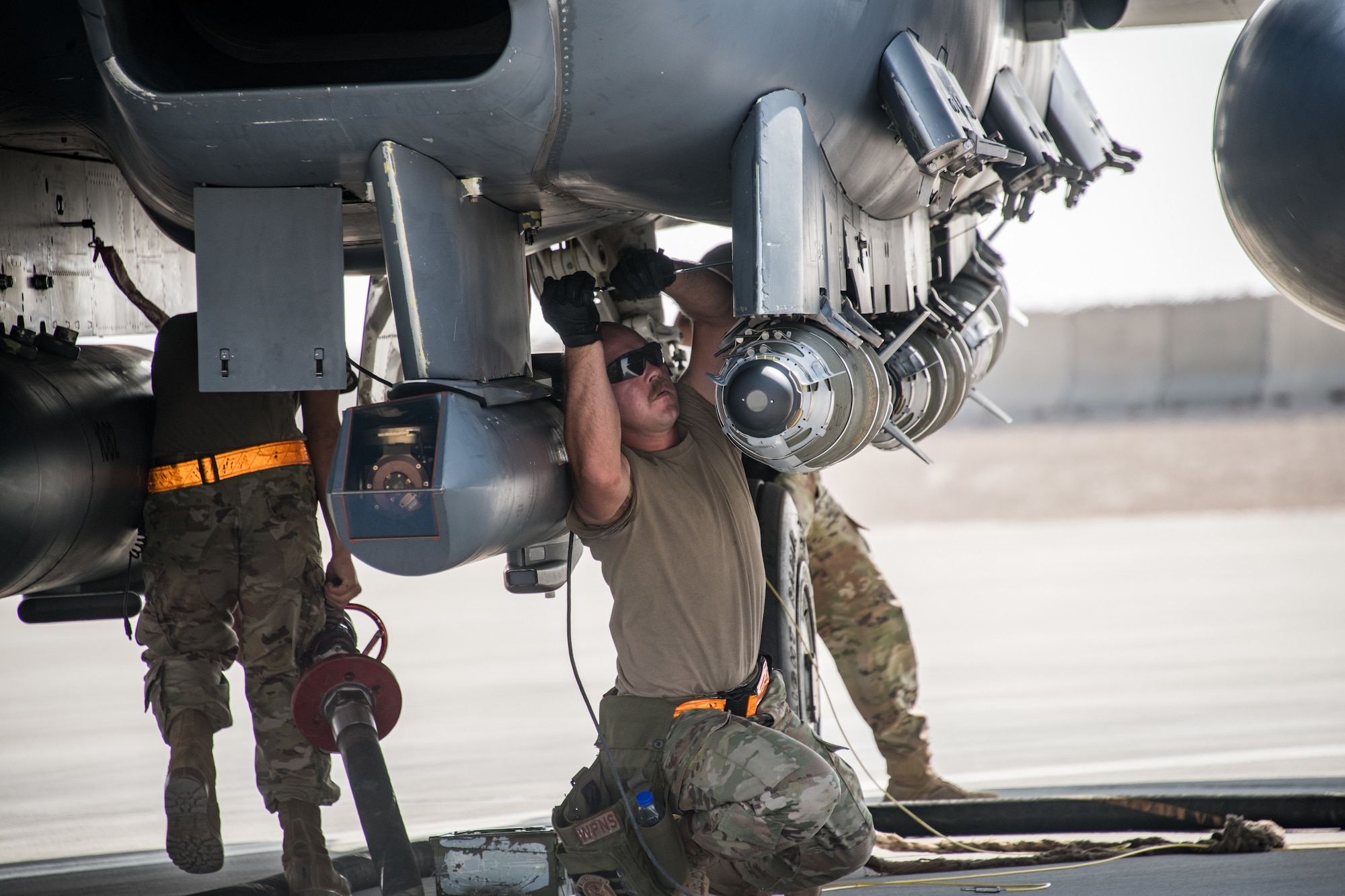 Airmen from the 379th Expeditionary Maintenance Squadron munitions flight load a GBU-38 Joint Direct Attack Munition onto an F-15E Strike Eagle during an integrated combat turn exercise at Al Udeid Air Base, Qatar, Mar. 3, 2021.