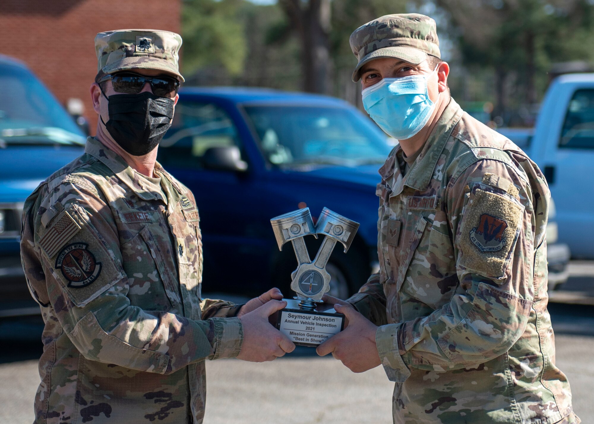 Lt. Col. Robert Fekete, left, 4th Logistics Readiness Squadron commander, presents Senior Airman Aaron Smith, right, 4th Civil Engineer Squadron pavement and equipment technician, with a trophy during a Vehicle Inspection Roll-By competition at Seymour Johnson Air Force Base, North Carolina, March 8, 2021.