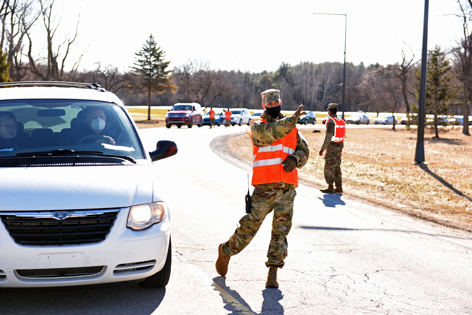 A Michigan Army National Guard Soldier directs traffic at a vaccination clinic at Delta College, University City, Michigan, March 6, 2021. The Guard helped vaccinate 2,600 residents during the two-day indoor/outdoor event.