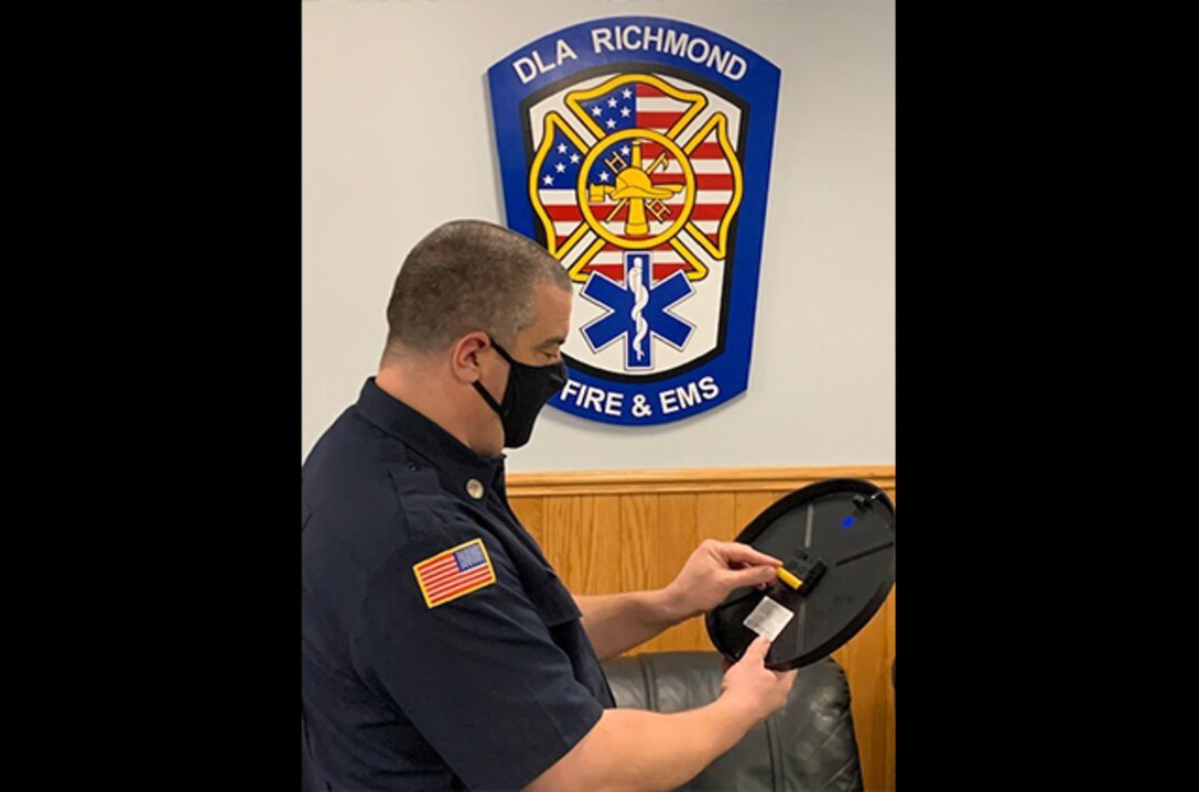 Fire Inspector Eric Crognale changes a clock battery