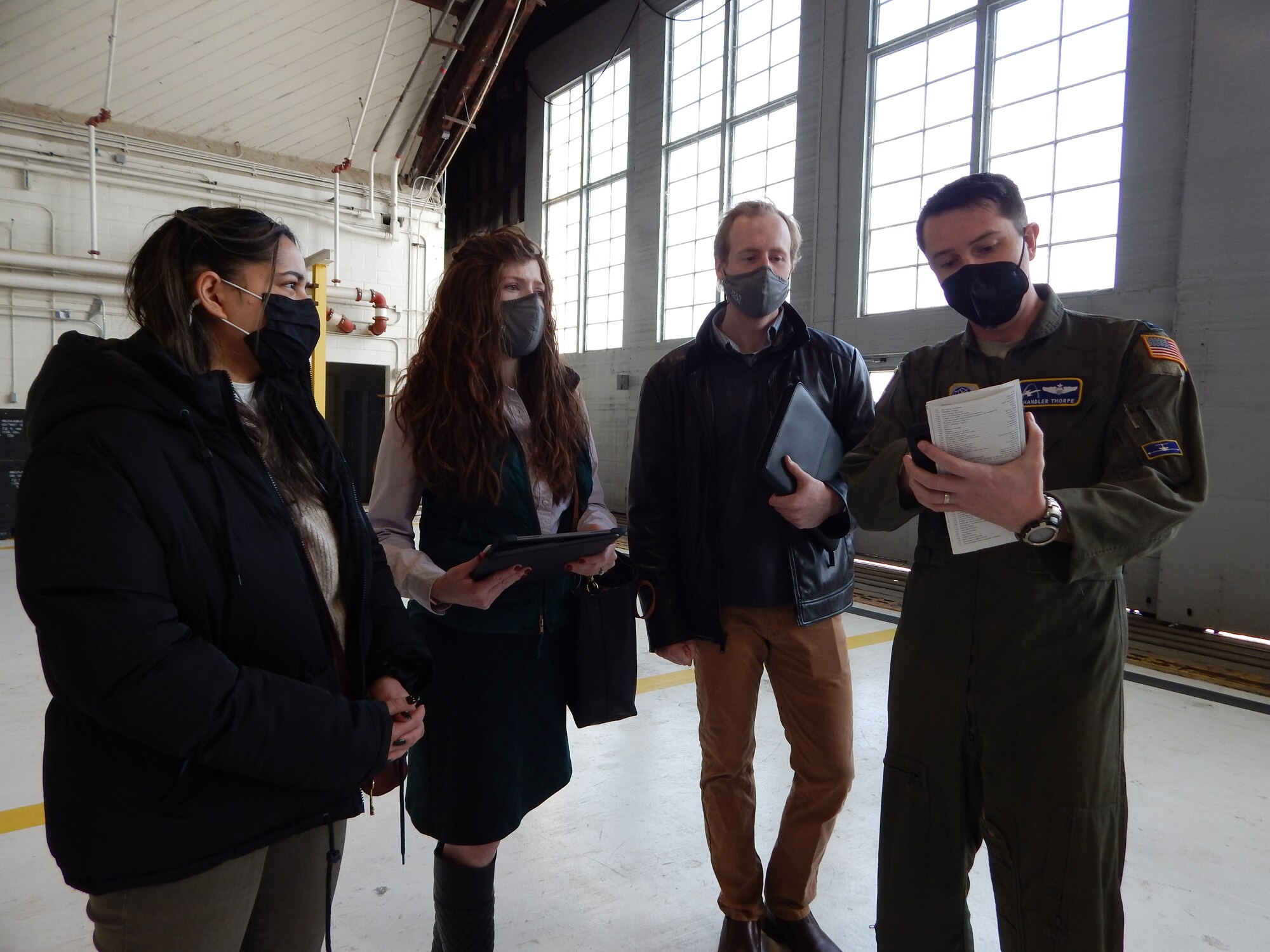 C-21 pilot Capt. Chandler Thorpe, 458th Airlift Squadron, shows Washington University graduate students (left to right) Mehir Walia, Kelsey Giaimo, and Kyle Gero a pre-flight checklist.  As part of the university’s Innovation for Defense Course, the students are working with Scott Air Force Base’s Elevate innovation team and the squadron to identify potential solutions that would resolve the current challenges C-21 pilots face training on a simulator that does not match the current, updated cockpit configuration.  (Photo by Christine Spargur)