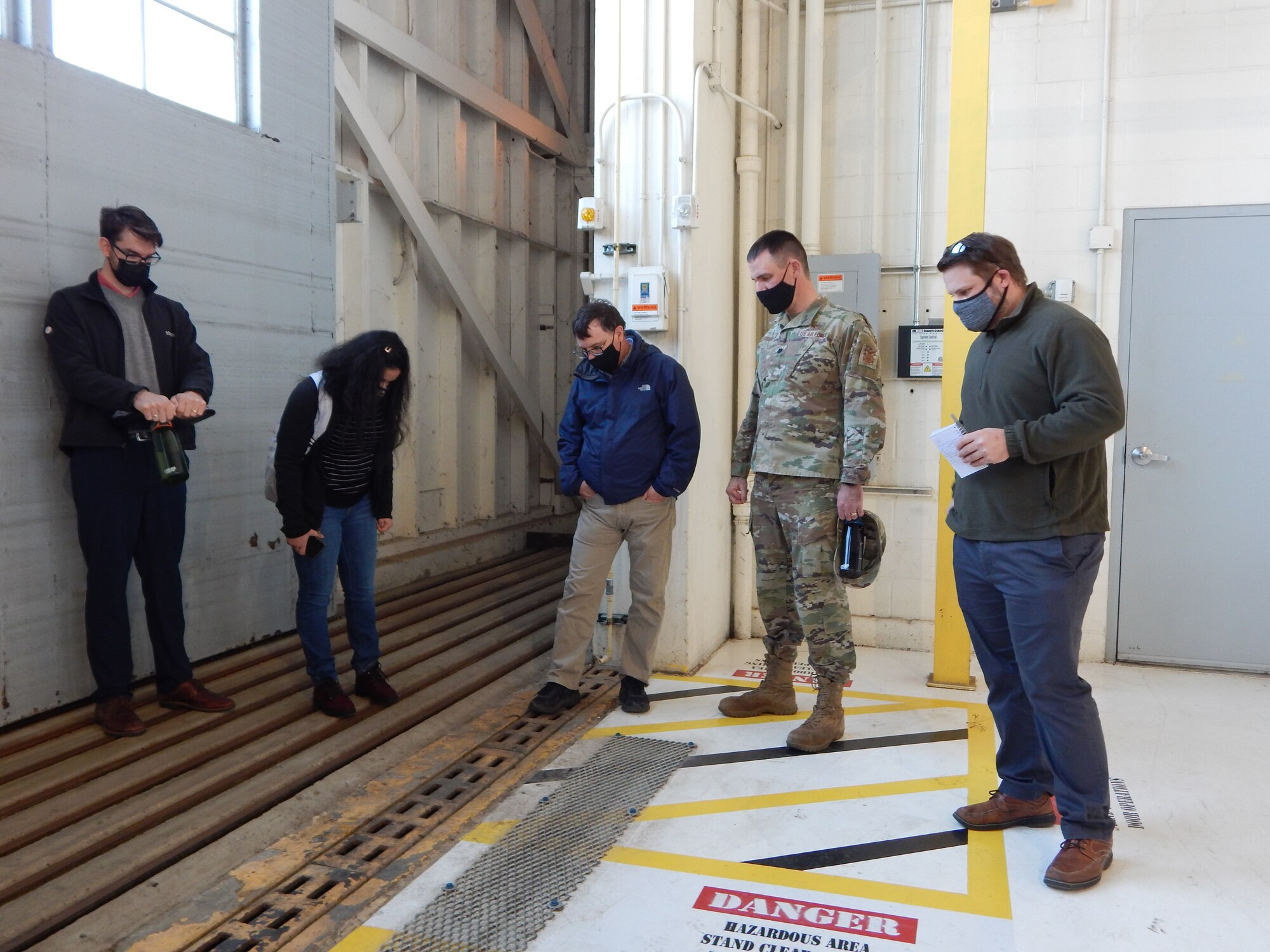 Washington University graduate students (left to right) Kyle Collier, Astha Bhatnagar, and Cam Loyet talk with 375th Civil Engineer Squadron’s Kenneth Cavanaugh (middle) and squadron commander Lt. Col. Paul Fredin about water drainage inside Hangar 3.  On Aug. 12, 2020, over five inches of rain fell within two hours on Scott Air Force Base causing damage to several buildings including the hangar. The students discussed several potential solutions to prevent future flooding inside the hangar. (Photo by Christine Spargur)