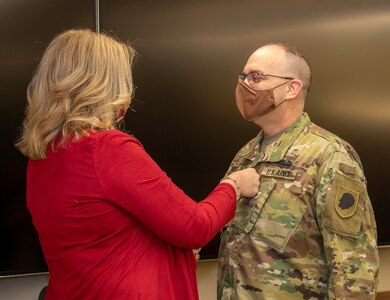 Newly promoted Col. Eric Davis’ wife, Bonnie, places his new rank on during a promotion ceremony Dec. 29 at Camp Lincoln in Springfield, Illinois. Davis, who has served in the military for 33 years, is the Deputy Chief of Staff for Plans, Operations and Training for the Illinois Army National Guard.