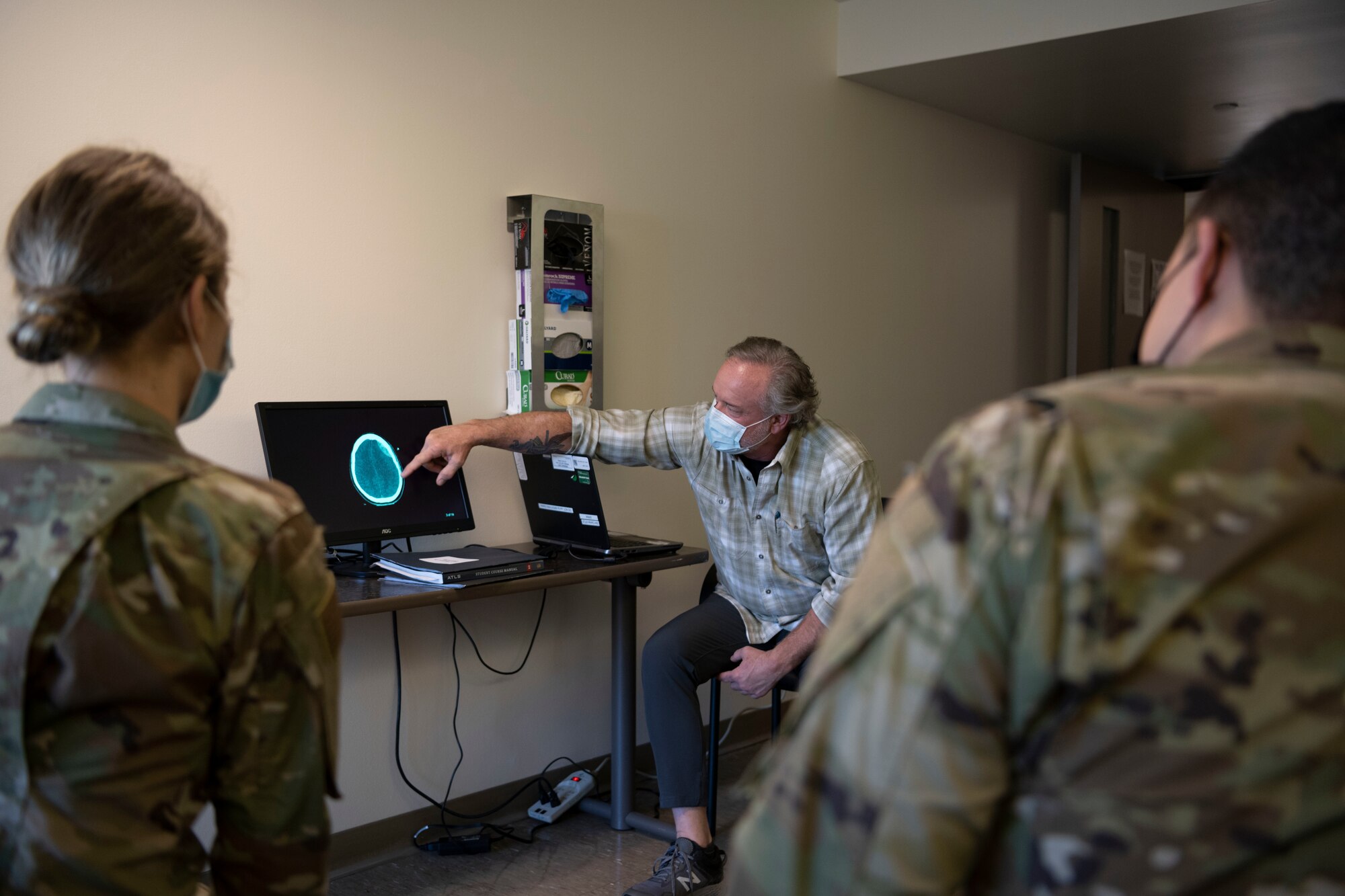 Chris Bandy, MD Fellow, American College of Surgeons, chief of trauma at Kaiser Permanente Vacaville Medical Center, points at a CT scan March 4, 2021, at Travis Air Force Base, California. Medical residents assigned to David Grant USAF Medical Center attended a disability skill station to identify traumatic brain injuries of a patient. (U.S. Air Force photo by Airman 1st Class Alexander Merchak)