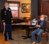 William Hills of Freeport, Illinois, shows off the U.S. flag and certificate presented by Lt. Col. Eric Smith of Springfield, Illinois, in honor of Hills’ 97th birthday Jan. 29.