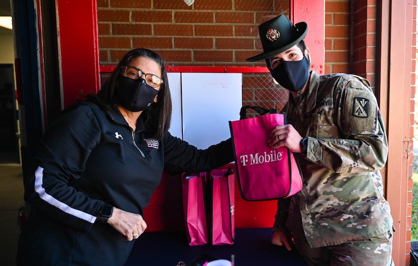 A USO volunteer hands a U.S. Army soldier a care package for International Women’s Day 2021 at Joint Base Langley-Eustis, Virginia, March 3, 2021.