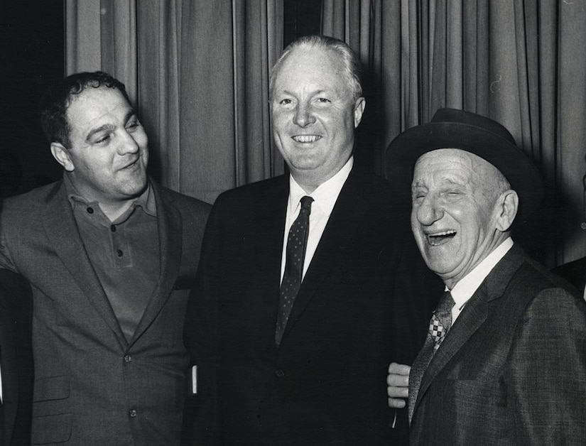 Three men pose for a photo.