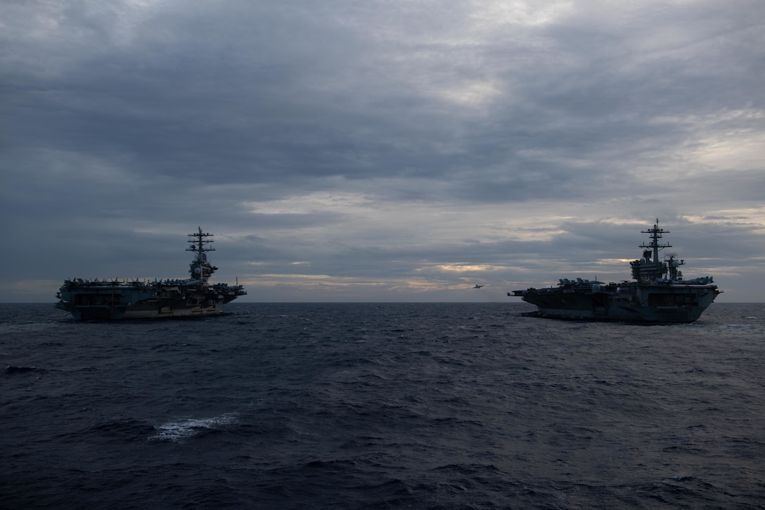Two aircraft carriers sail in formation in the Pacific.