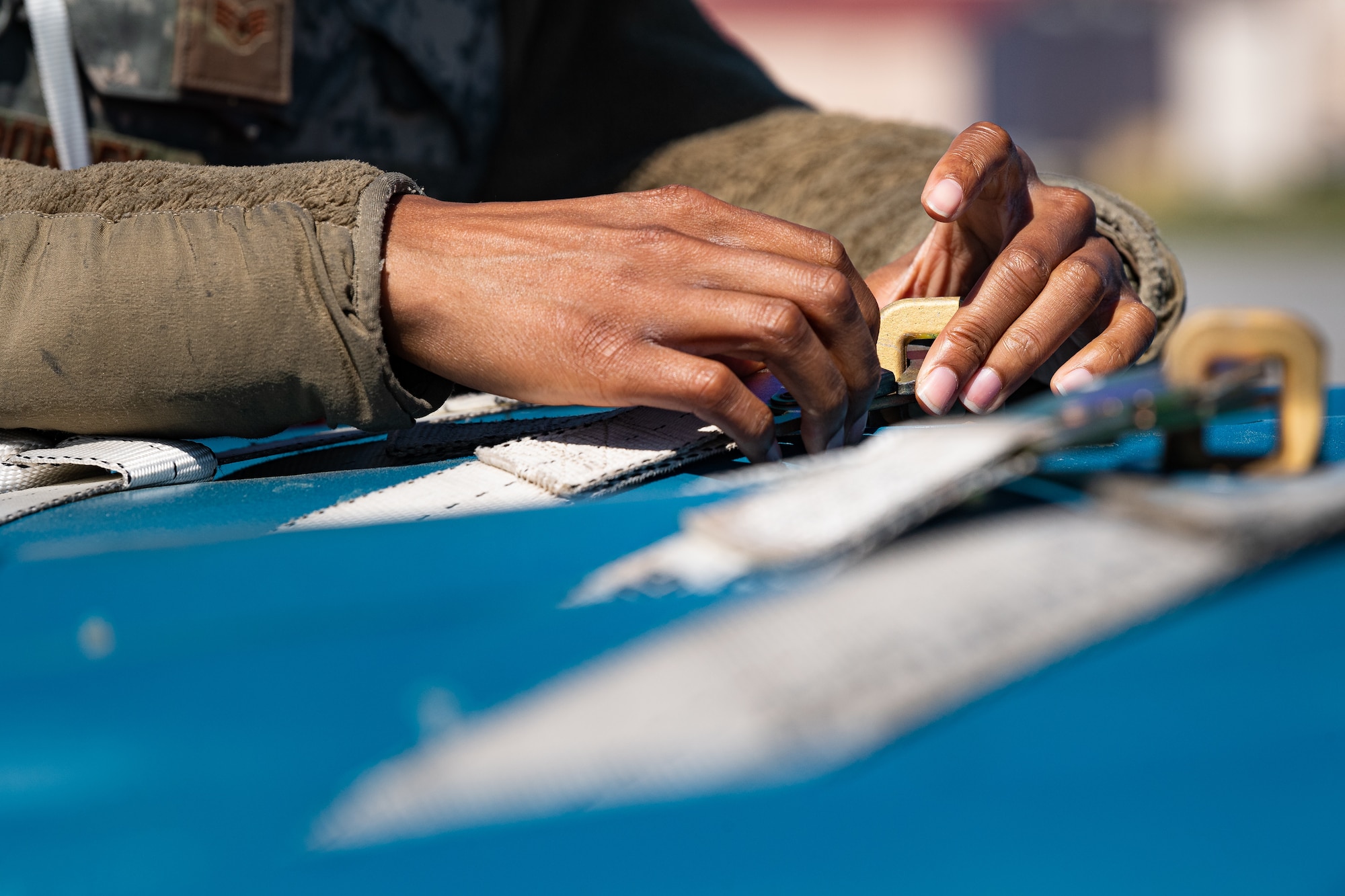 A photo of an Airman removing a strap from a practice bomb