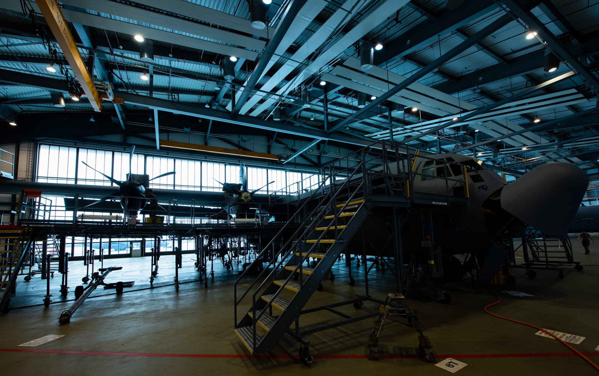 A C-130J Super Hercules aircraft undergoes an isochronal inspection in a maintenance hangar