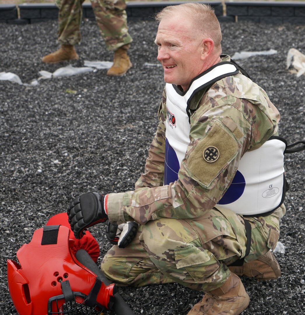Chief Warrant Officer 2 Thomas Downer takes a breather before competing in the final round of the pugile stick fight on day three of the competition at Joint Base San Antonio-Camp Bullis Feb. 25.