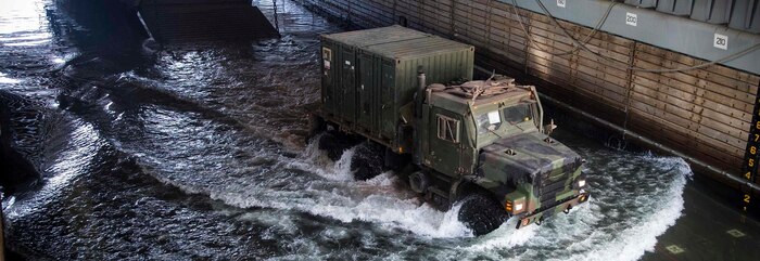 GULF OF ADEN - A U.S. Marine Medium Tactical Vehicle Replacement 7-ton truck with Combat Logistics Battalion 13, 13th Marine Expeditionary Unit (MEU), drives onto the well deck from Landing Craft Utility 1680 aboard the Whidbey Island-class dock landing ship USS Rushmore (LSD 47), Sept. 20, 2018. The Essex Amphibious Ready Group and 13th MEU are deployed to the U.S. 5th Fleet area of operations in support of naval operations to ensure maritime stability and security in the Central Region, connecting the Mediterranean and the Pacific through the western Indian Ocean and three strategic choke points. (U.S. Marine Corps photo by Cpl. Danny Gonzalez/Released)