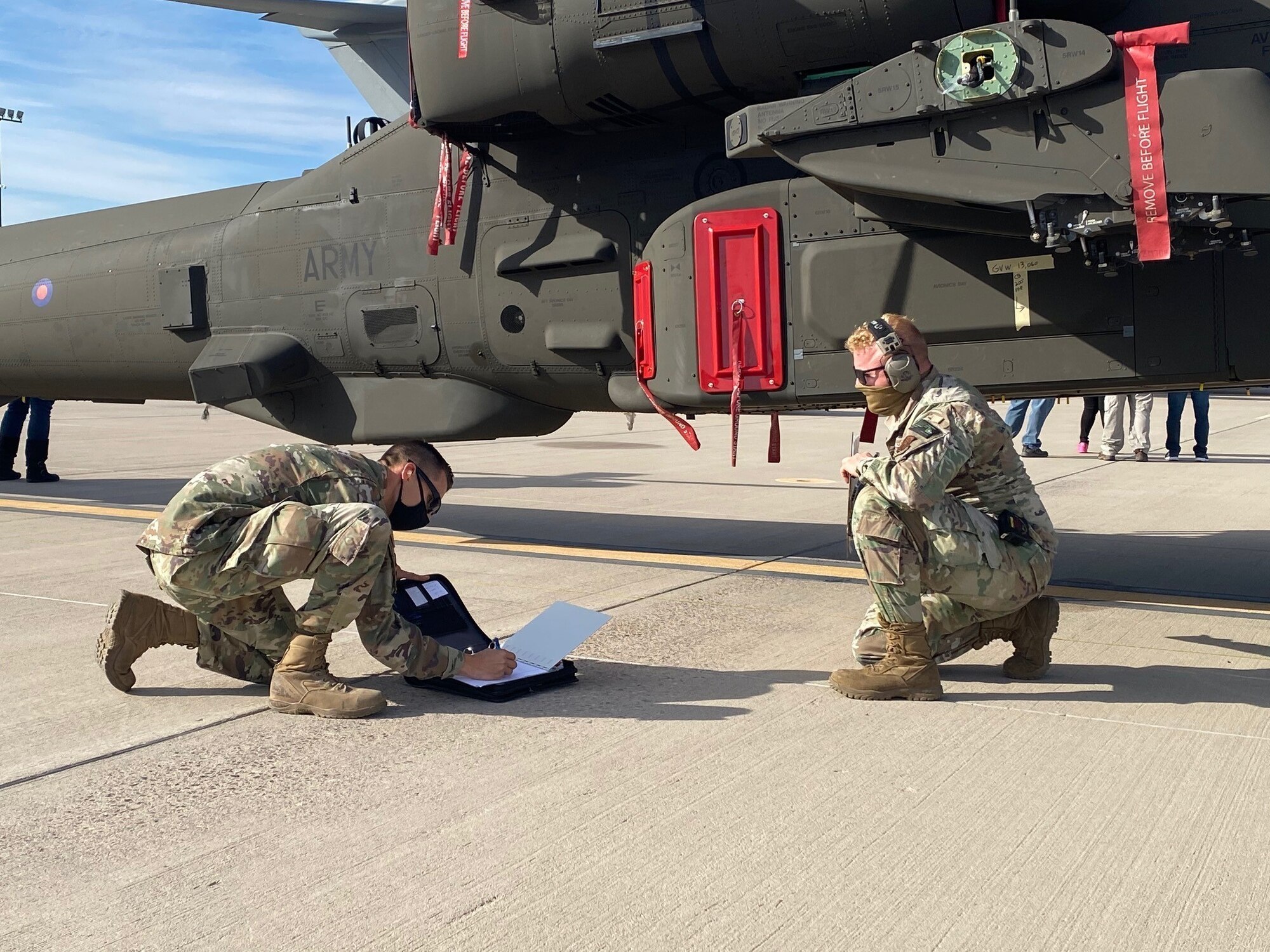 Staff Sgt. Chaz Bruno and Staff Sgt. Joe Franzen, air cargo specialists with the 161st Logistics Readiness Squadron, conduct a preflight inspection of an AH-64 Apache helicopter at the Goldwater Air National Guard Base in Phoenix, Arizona, Jan. 21, 2021. The 161st was contacted by the U.S. Army’s Apache foreign military sales program office to help load the attack helicopters on C-17 aircraft for shipment to the United Kingdom.