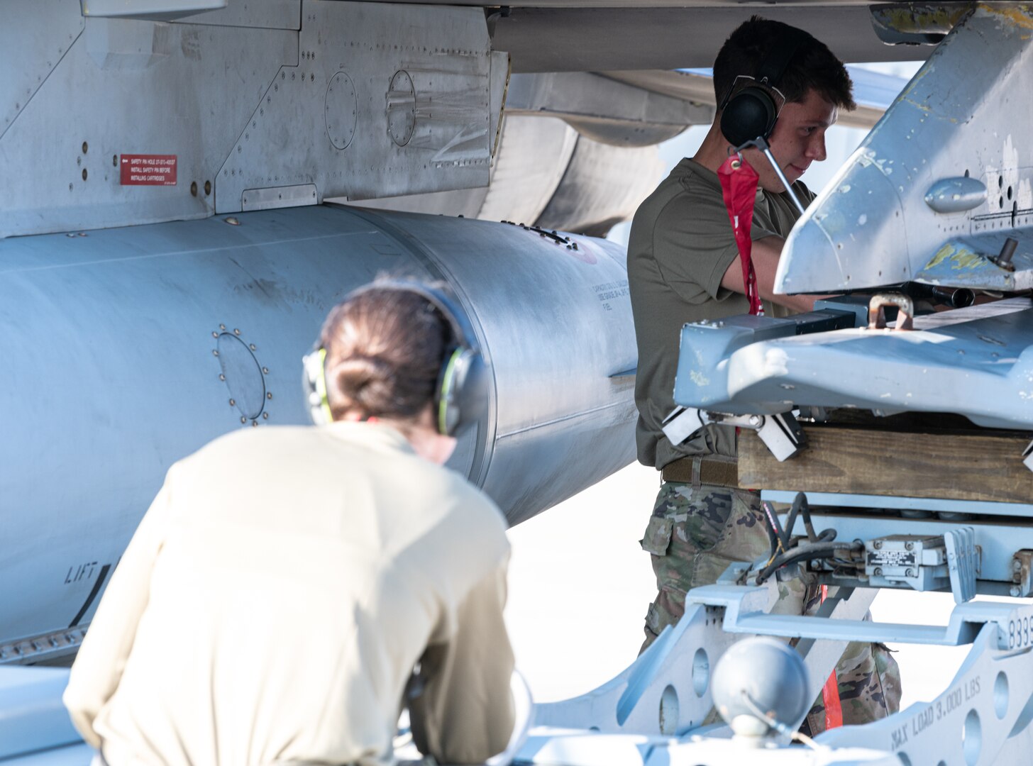 Senior Airman Ramos, 77th Expeditionary Fighter Generation Squadron weapons load crew member, guides a munition onto an F-16 Fighting Falcon before a flight during an Agile Combat Employment capstone event Feb. 27, 2021, at an airbase in the Kingdom of Saudi Arabia.