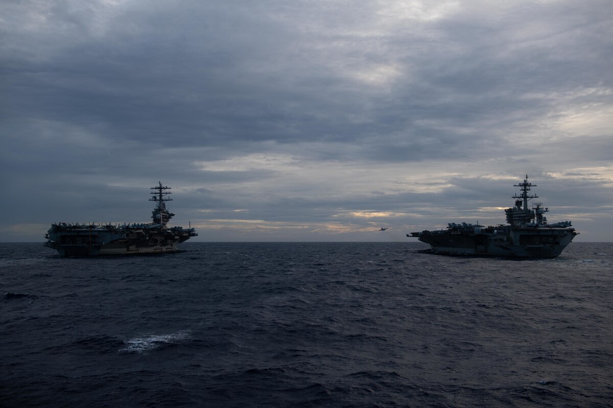Two aircraft carriers sail in formation in the Pacific.