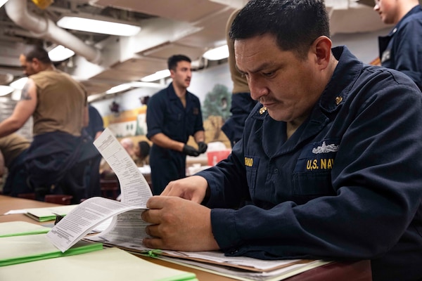 210220-N-BM428-0122 SOUDA BAY, Greece (Feb. 20, 2021) Senior Chief Hospital Corpsman Andre Naranjo verifies paperwork for Sailors aboard the Arleigh Burke-class guided-missile destroyer USS Porter (DDG 78) in roder for them to receive the COVID-19 vaccine in Souda Bay, Greece, Feb. 20, 2021. Porter, forward deployed to Rota, Spain, is on its ninth patrol in the U.S. Sixth Fleet area of operations in support of U.S. national interests and security in Europe and Africa. (U.S. Navy photo by Mass Communication Specialist 2nd Class Damon Grosvenor)