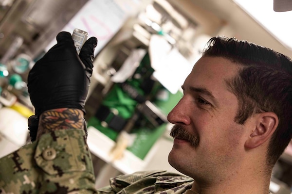 210220-N-BM428-0143 SOUDA BAY, Greece (Feb. 20, 2021) Hospital Corpsman 3rd Class Zak McBride, assigned to Naval Hospital Souda Bay, prepares a COVID-19 vaccine for use aboard the Arleigh Burke-class guided-missile destroyer USS Porter (DDG 78) in Souda Bay, Greece, Feb. 20, 2021. Porter, forward deployed to Rota, Spain, is on its ninth patrol in the U.S. Sixth Fleet area of operations in support of U.S. national interests and security in Europe and Africa. (U.S. Navy photo by Mass Communication Specialist 2nd Class Damon Grosvenor)