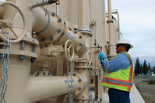 Technicians draw a water sample