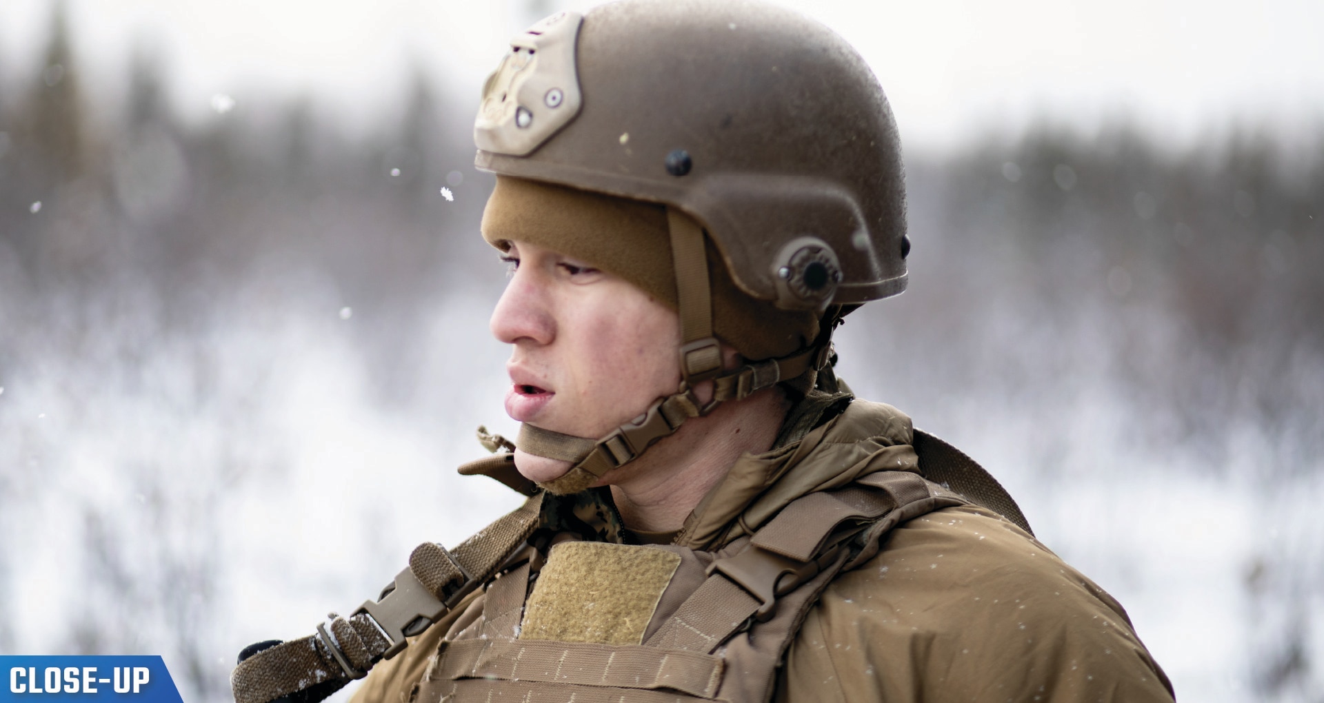 U.S. Marine Corps Lance Cpl. in gear standing in snow.