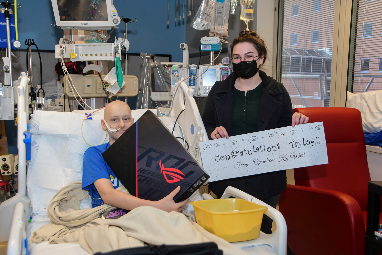 Taylor Roberts, a patient at Naval Medical Center Portsmouth’s (NMCP) Pediatric Oncology Department, receives a gaming gift from Operation Key West, March 4