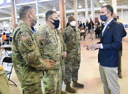 Commonwealth of Virginia and Virginia National Guard senior leaders visit with Soldiers providing logistics and administrative support to a COVID-19 community vaccination site at Richmond Raceway March 8, 2021, in Henrico County, Virginia.