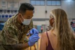 Hawaii National Guard Spc. Jonathan Ganir, assigned to Task Force Hawaii, administers a COVID-19 vaccine to a Department of Education employee at Kealakehe High School, March 6, 2021, Kona, Hawaii. Over 700 DOE employees received their second dose of COVID-19 vaccines during the event.
