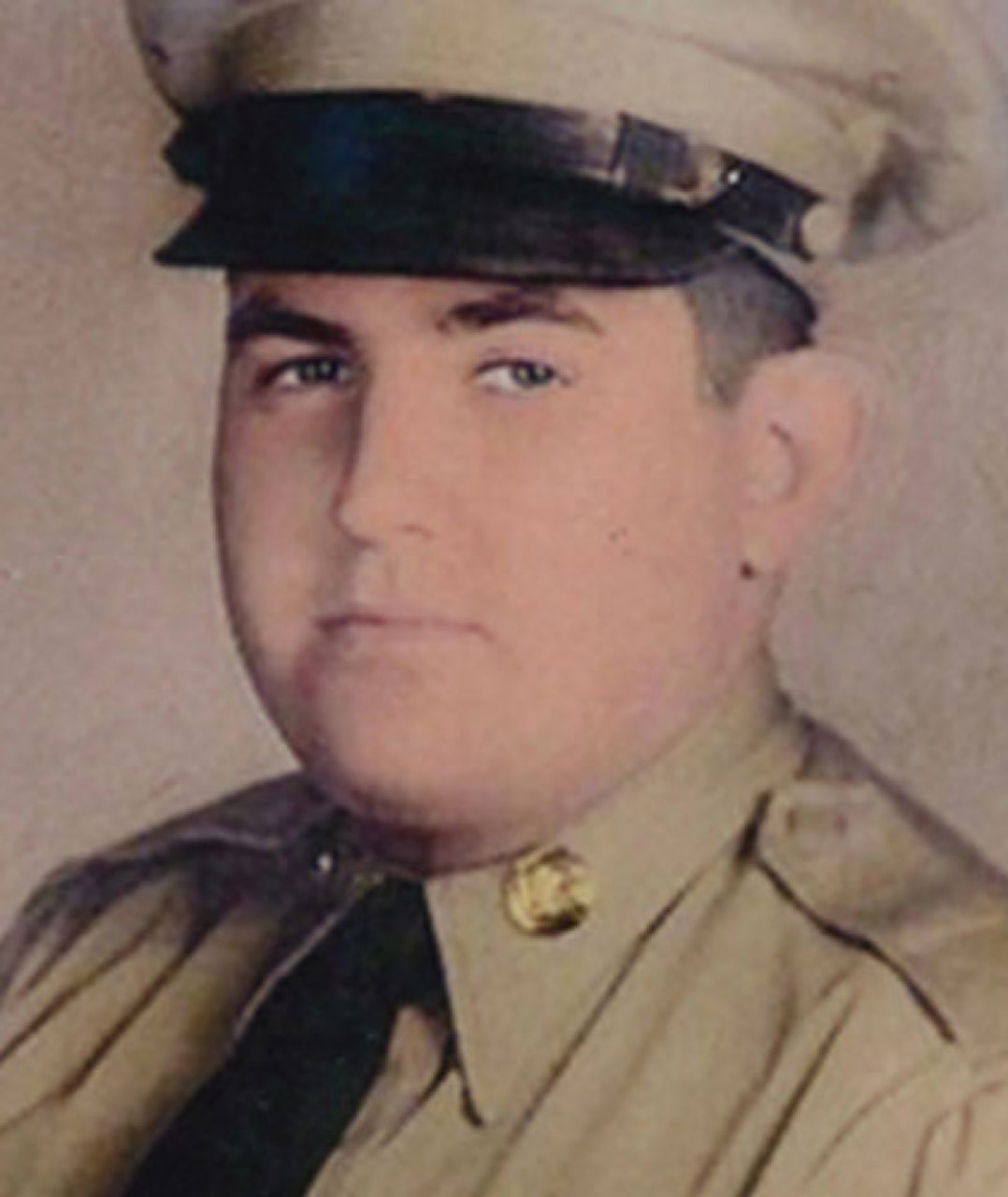 A young man in uniform poses for the camera.