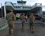 Service members with Joint Task Force Steelhead's mobile vaccination team board a Washington State ferry en route to Orcas Island, Washington, March 2, 2021. The Washington National Guard’s MVT travels around the state, delivering and administering the COVID-19 vaccine to high-risk communities and remote areas.