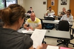 Amanda Hayman, Embry-Riddle Aeronautical University adjunct instructor, reviews the course syllabus with students on the second floor of the training building, Oct. 21.
