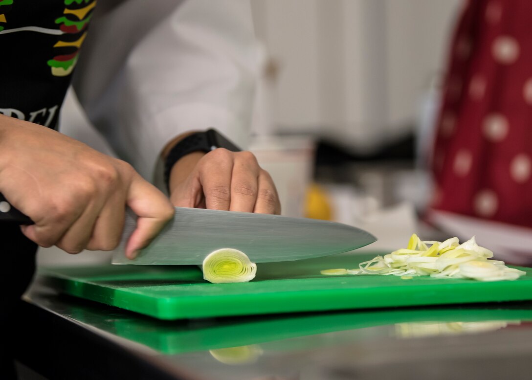 A woman chops vegetables.